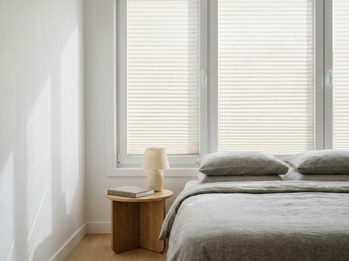 Chambre contemporaine avec store cellulaire alvéolaire installé en tableau de fenêtre, démonstration de l'isolation thermique et de la protection solaire intérieure